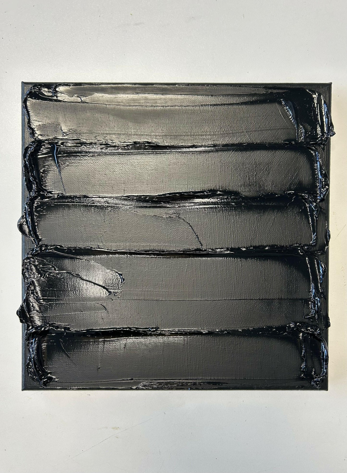 abstract textured oil painting black canvas on white wall by Caroline Adrienne Art