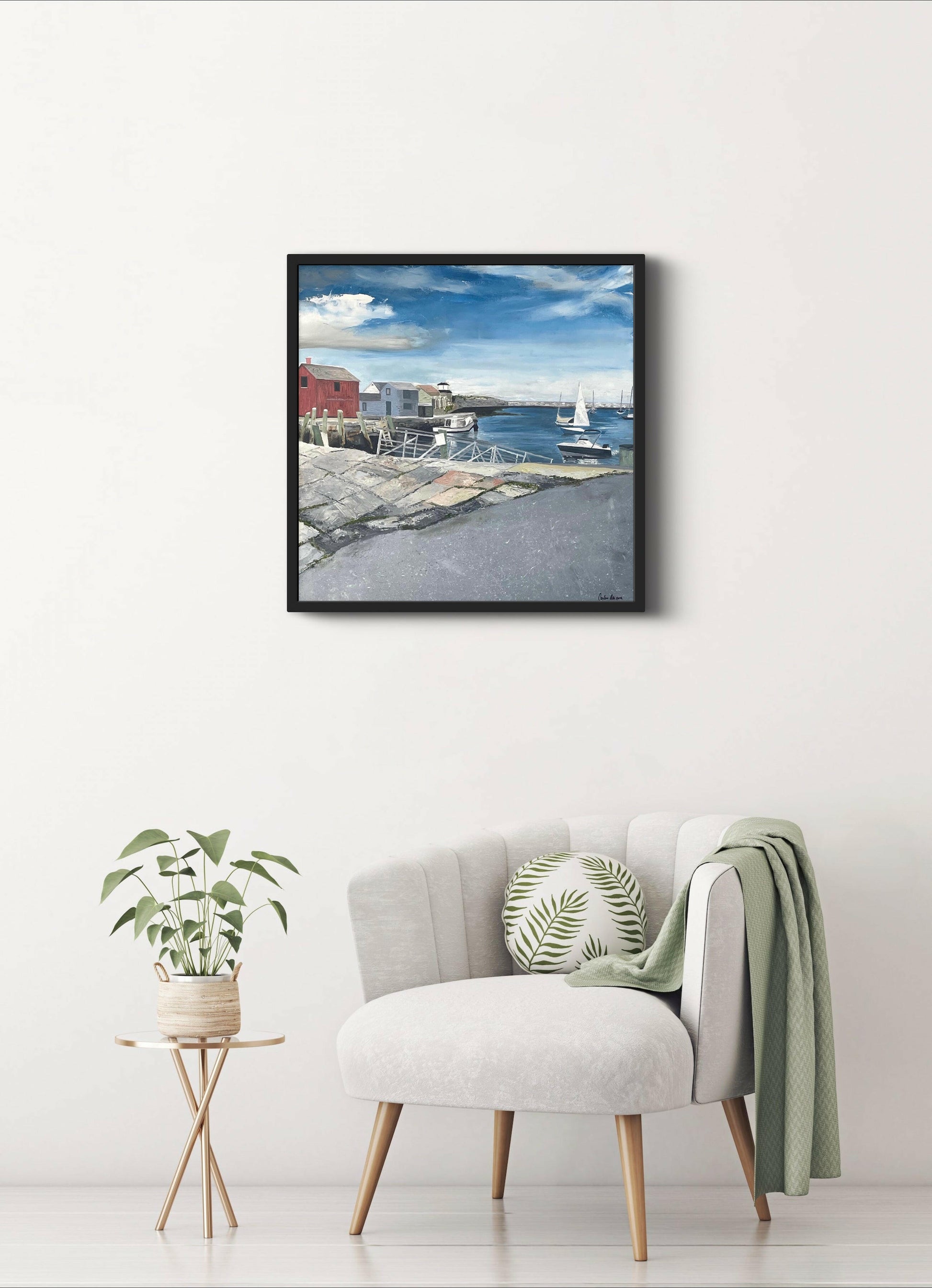 An original abstract art oil painting depicting a seaside scene with a red fishing shack, displayed on a wall above a sofa with a neutral gray frame.