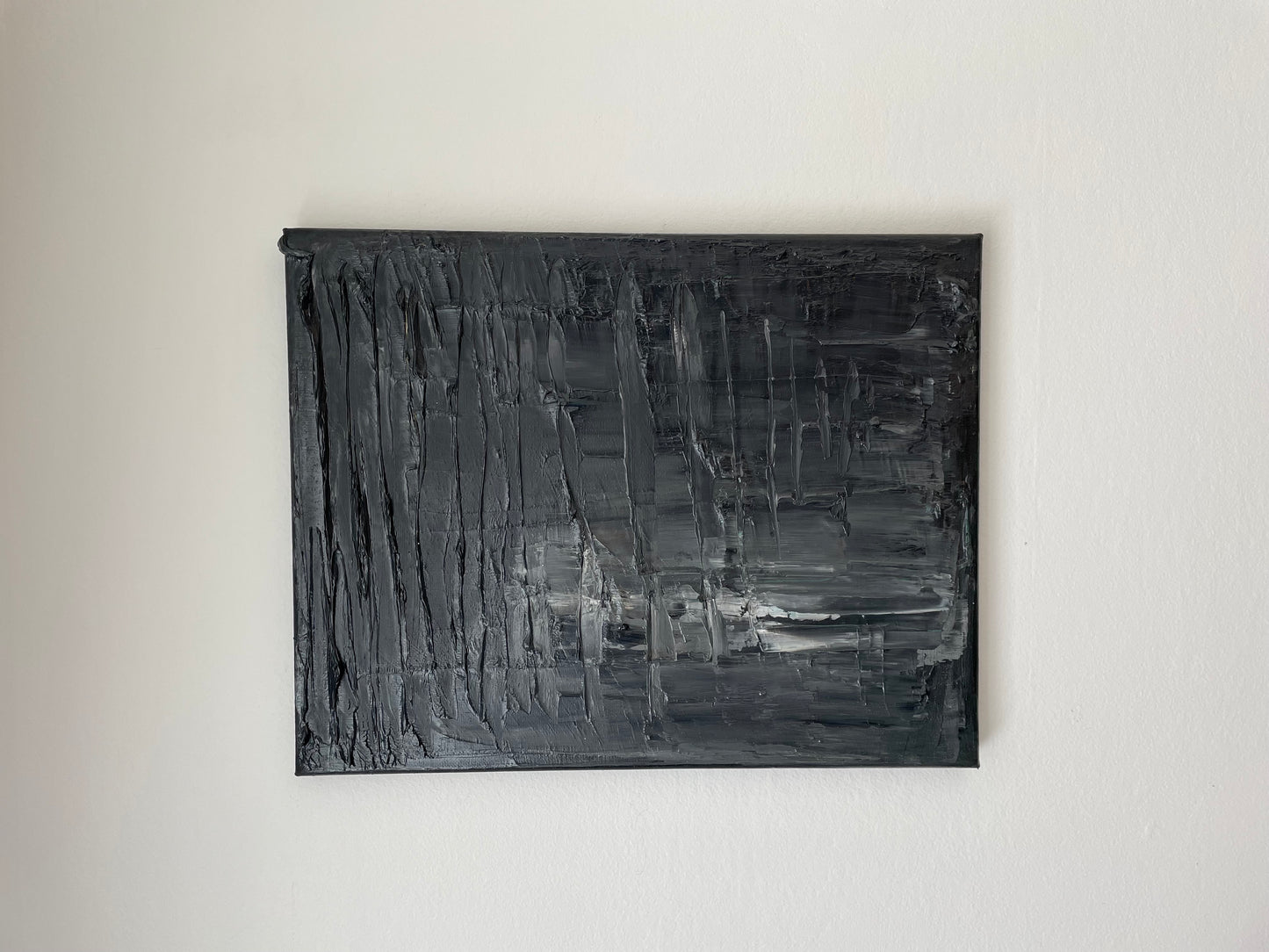 Abstract black and gray painting on a white wall