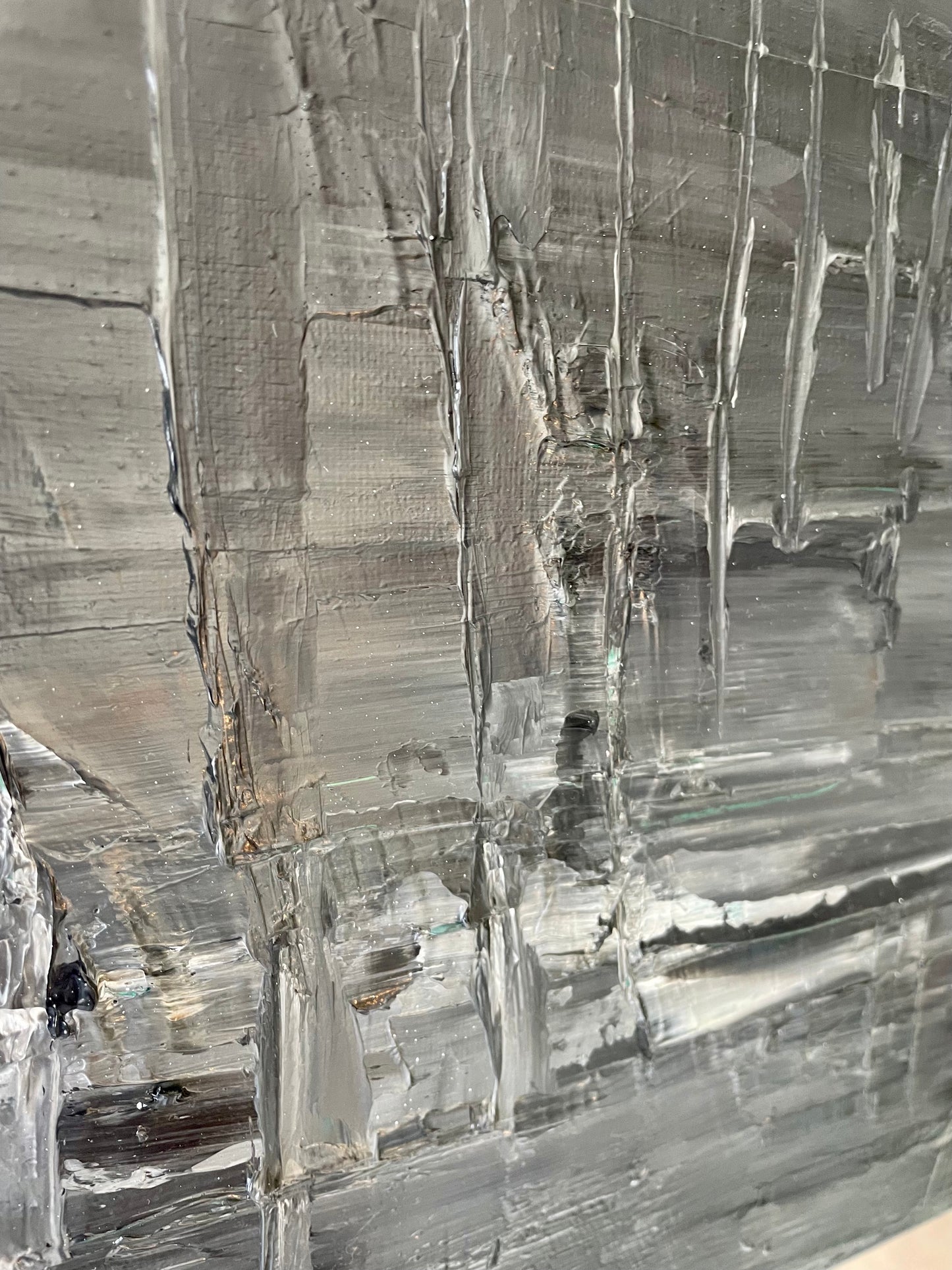 Close-up of a textured painting with reflective surface