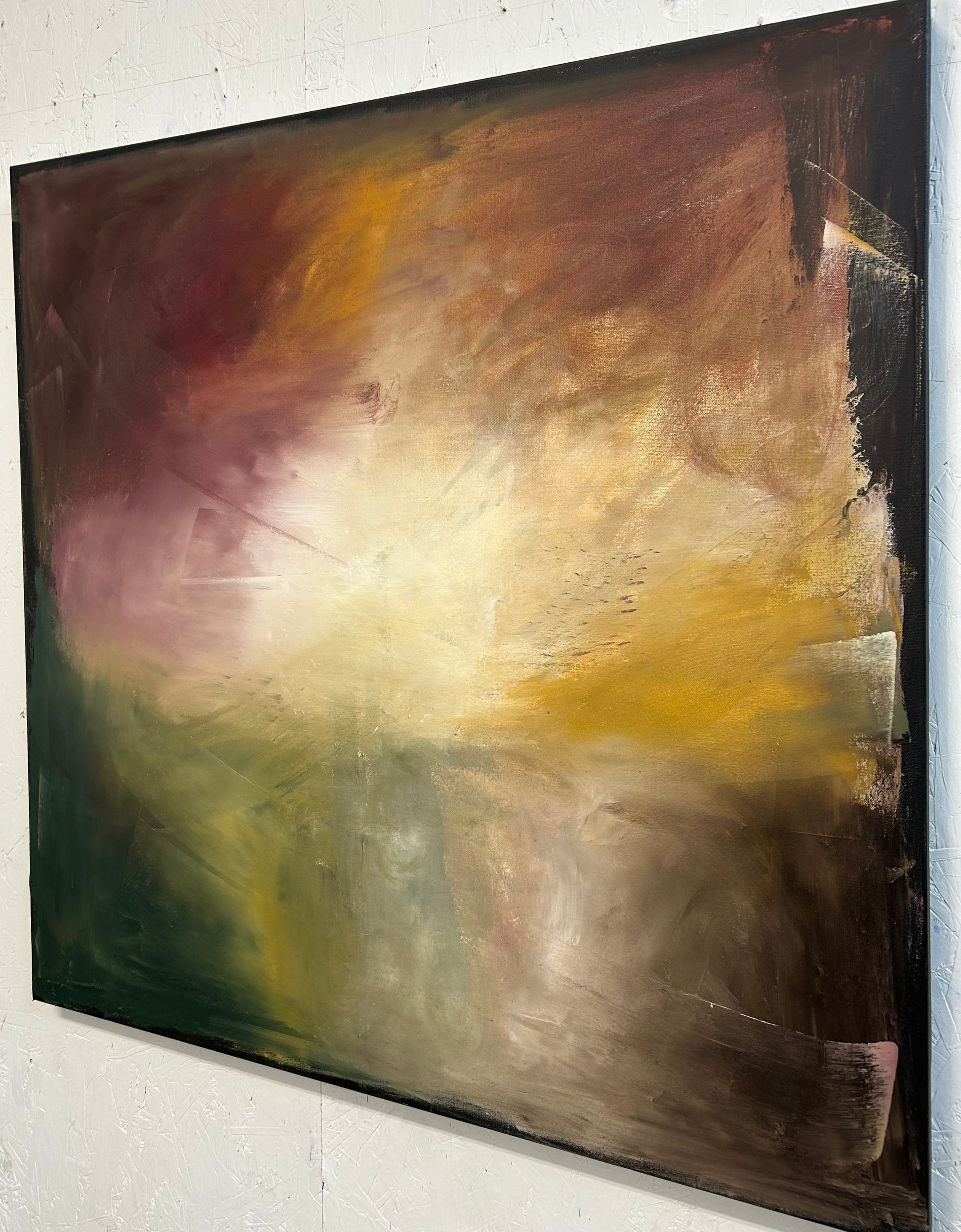 Abstract painting with brown, yellow, and green colors on a white wall.